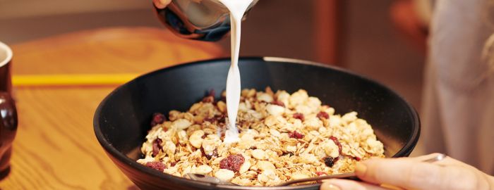 Pouring milk to muesli bowl
