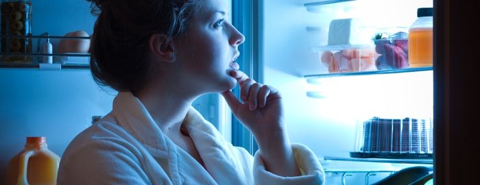 A lady staring into the fridge