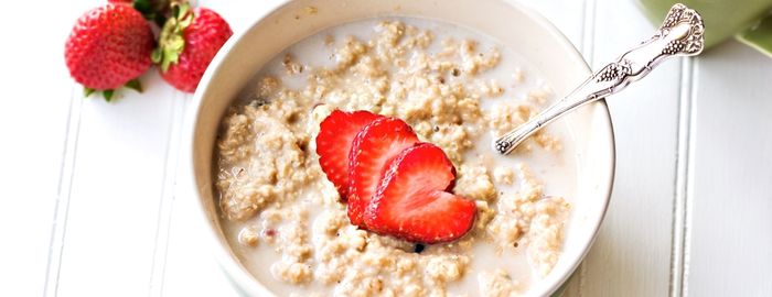 A bowl of oatmeal with strawberries